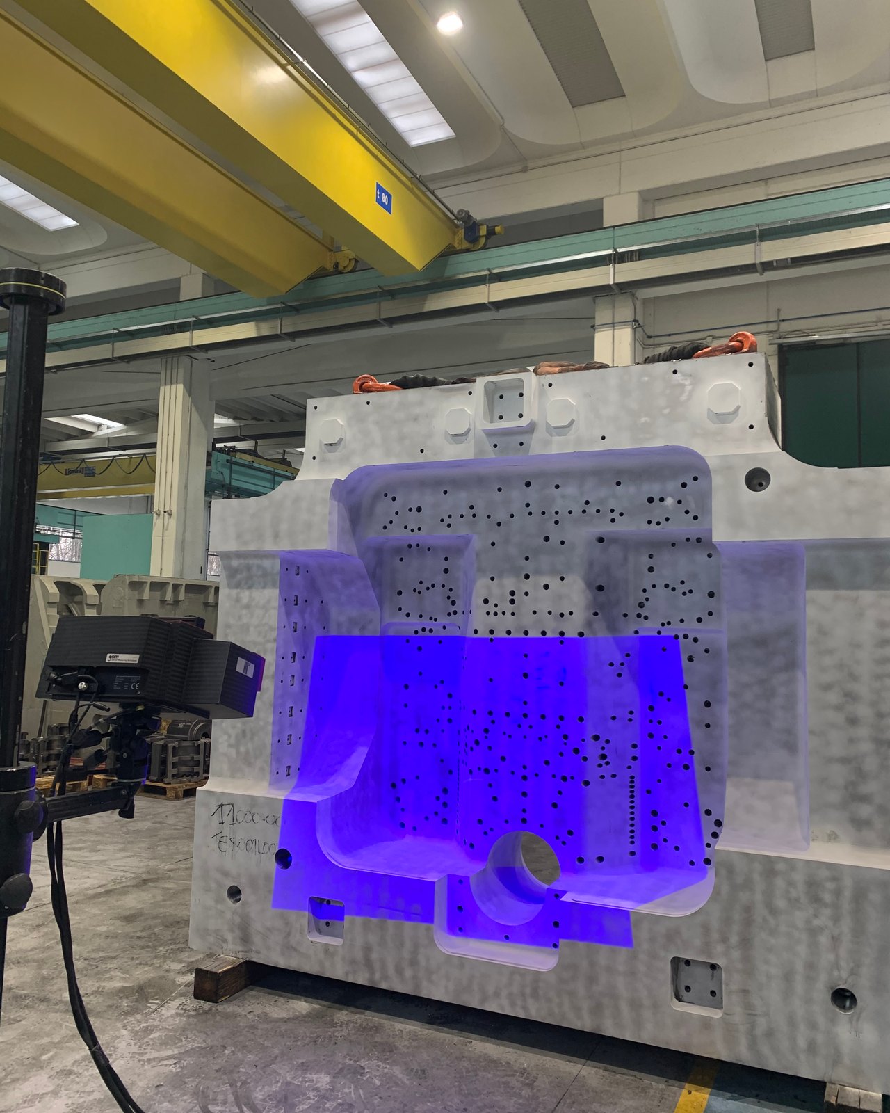 Scanner 3D che proietta luce blu strutturata su un grande componente lavorato